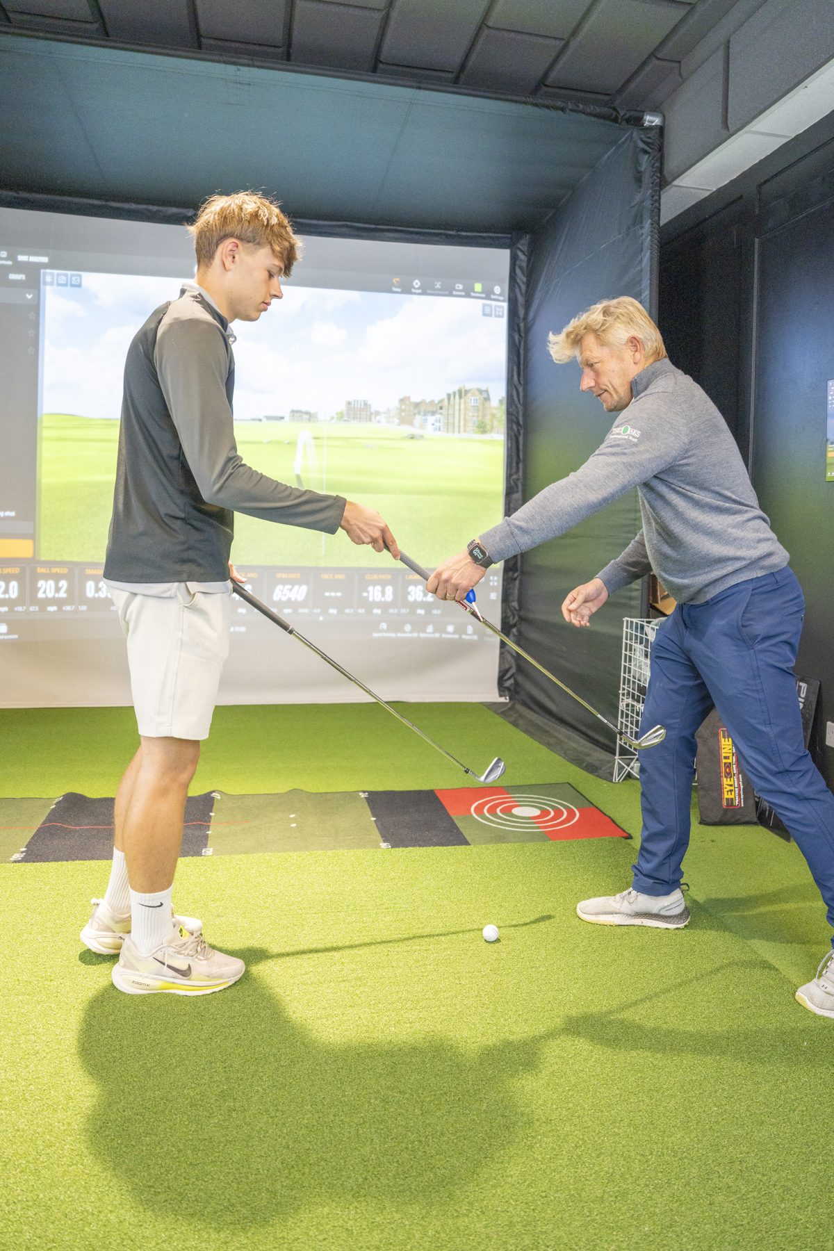 Jon Good adjusting a golfer's grip in the Trackman studio